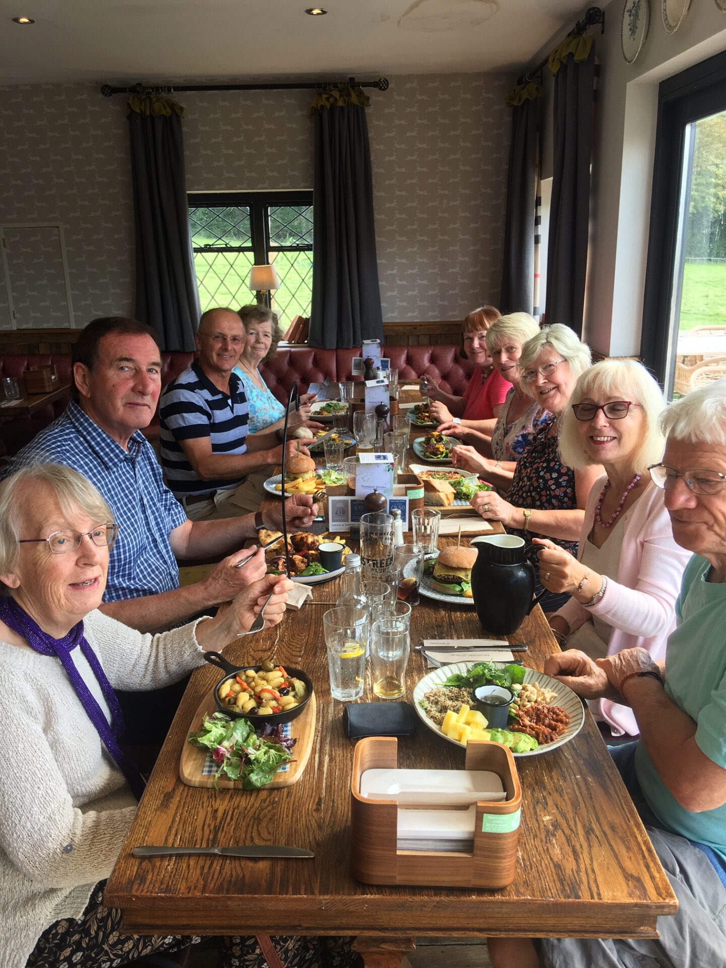 a group of people sitting at a table a pub enjoying lunch.
